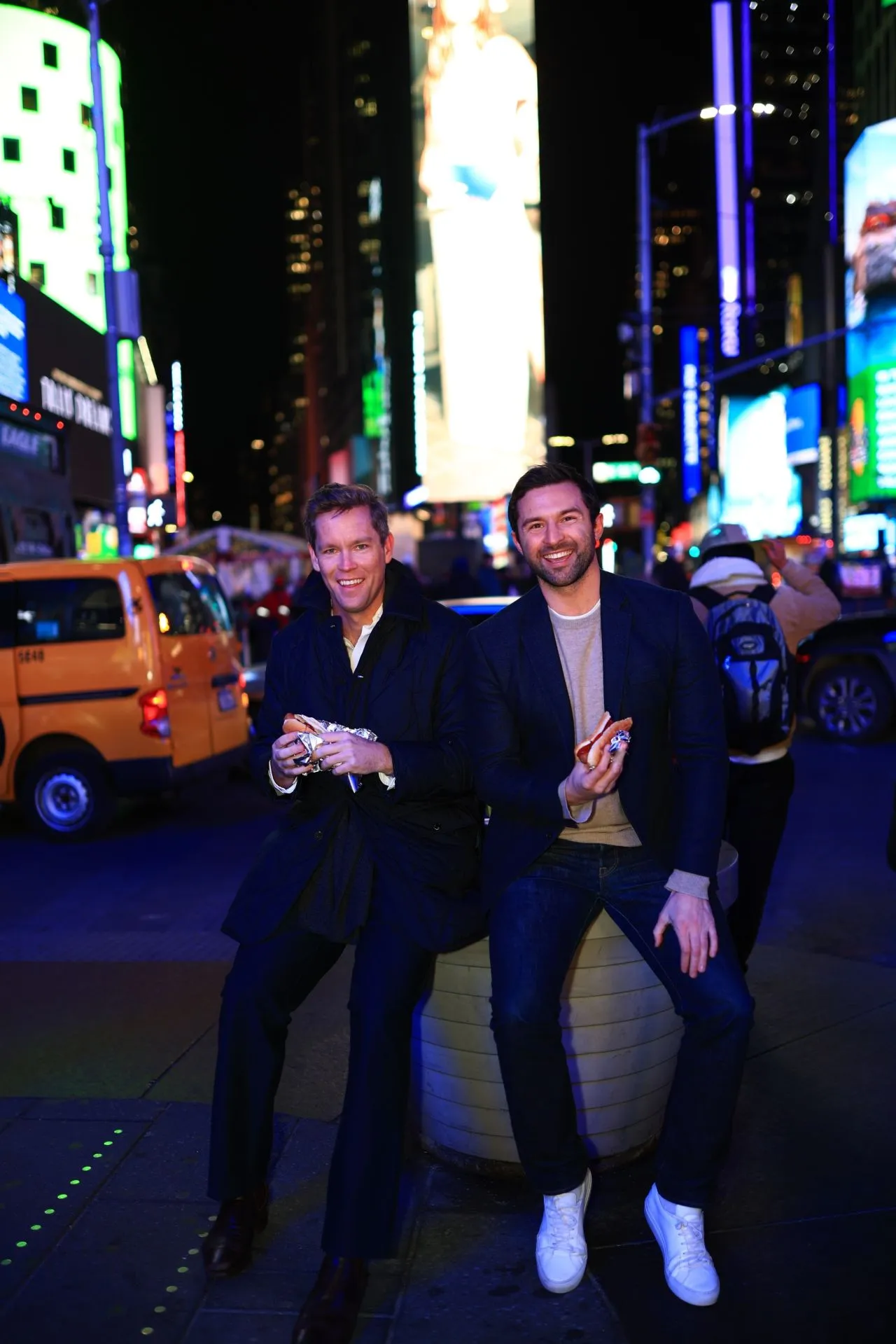 Topham Guerin co-founder Sean Topham and TG USA managing director Guy Creighton in New York’s Times Square at night, lit by the city’s billboards