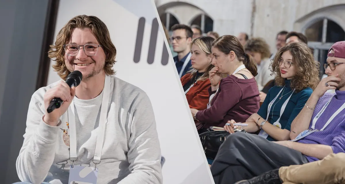 Ben Guerin speaking into a microphone at the Political Tech Summit in Berlin, January 2026, beside an audience of young political communications professionals.