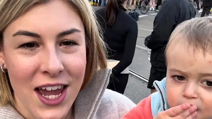 Victorian Opposition Leader Jess Wilson filming a selfie video outdoors, with a young child beside her.